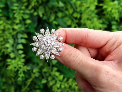 fig 1. An antique Edwardian silver-topped diamond star brooch featuring a central round diamond surrounded by diamond-paved star rays and ball terminals.