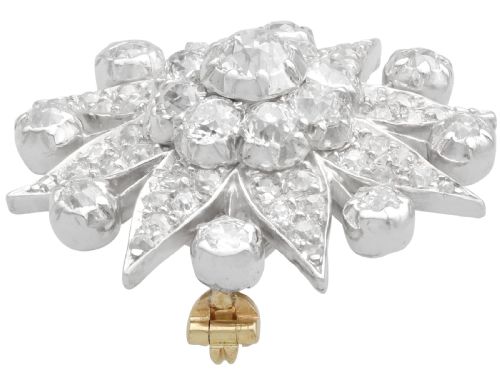 fig 3. An antique Edwardian silver-topped diamond star brooch featuring a central round diamond surrounded by diamond-paved star rays and ball terminals.