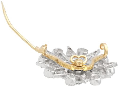 fig 6. An antique Edwardian silver-topped diamond star brooch featuring a central round diamond surrounded by diamond-paved star rays and ball terminals.