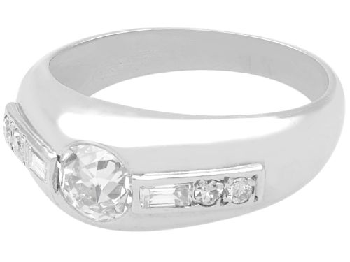 fig 1. A vintage platinum ring featuring a centre round brilliant diamond flanked by baguette and round cut diamonds set into a broad band.
