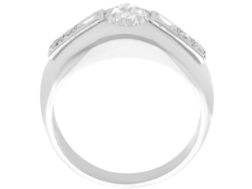 fig 3. A vintage platinum ring featuring a centre round brilliant diamond flanked by baguette and round cut diamonds set into a broad band.