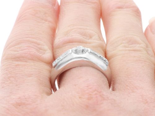 fig 6. A vintage platinum ring featuring a centre round brilliant diamond flanked by baguette and round cut diamonds set into a broad band.
