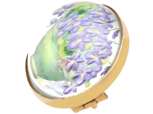 fig 4. An oval 14ct yellow gold brooch set with a reverse-carved glass cabochon displaying purple violets in a green vase.
