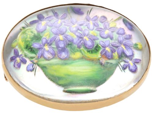fig 5. An oval 14ct yellow gold brooch set with a reverse-carved glass cabochon displaying purple violets in a green vase.