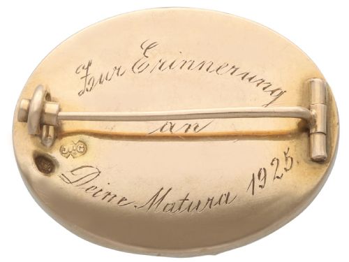 fig 6. An oval 14ct yellow gold brooch set with a reverse-carved glass cabochon displaying purple violets in a green vase.