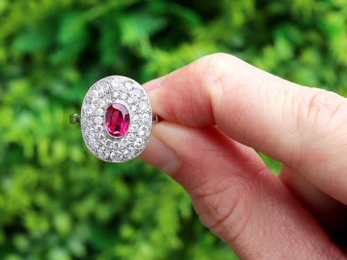 fig 1. An 18ct white gold halo ring featuring a central oval red ruby surrounded by two tiers of round diamonds.