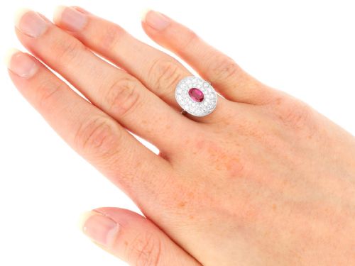 fig 9. An 18ct white gold halo ring featuring a central oval red ruby surrounded by two tiers of round diamonds.