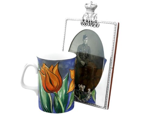 fig 2. A rectangular sterling silver picture frame featuring an oval aperture, topped with a royal crown monogram and detailed with a laurel wreath emblem at the base.