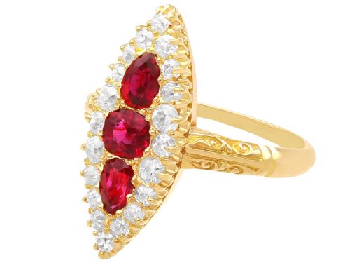 fig 5. An antique 18ct yellow gold navette dress ring featuring three central red rubies surrounded by a border of diamonds and finished with scroll-carved shoulders.