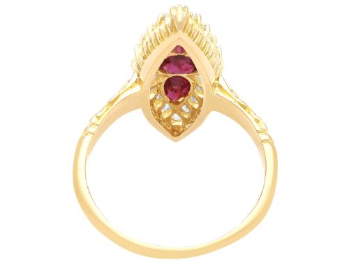 fig 6. An antique 18ct yellow gold navette dress ring featuring three central red rubies surrounded by a border of diamonds and finished with scroll-carved shoulders.