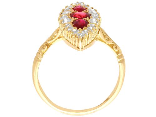fig 7. An antique 18ct yellow gold navette dress ring featuring three central red rubies surrounded by a border of diamonds and finished with scroll-carved shoulders.
