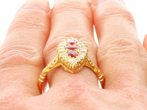 fig 10. An antique 18ct yellow gold navette dress ring featuring three central red rubies surrounded by a border of diamonds and finished with scroll-carved shoulders.