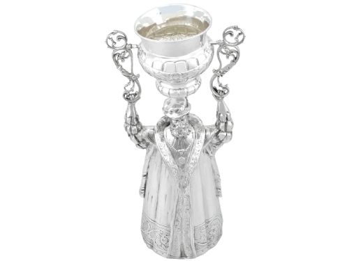 fig 1. A Victorian sterling silver wager cup depicting a bearded male figure holding a double-handled vessel above his head.