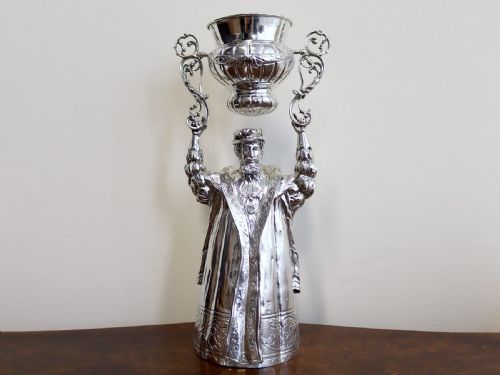 fig 2. A Victorian sterling silver wager cup depicting a bearded male figure holding a double-handled vessel above his head.