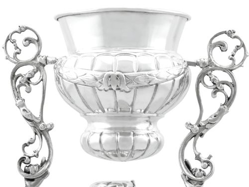 fig 8. A Victorian sterling silver wager cup depicting a bearded male figure holding a double-handled vessel above his head.