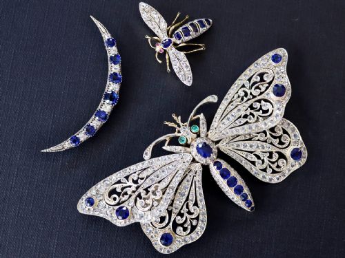fig 2. An antique butterfly brooch constructed from gold and silver, featuring openwork wings set with diamonds, sapphire details, and green emerald eyes.