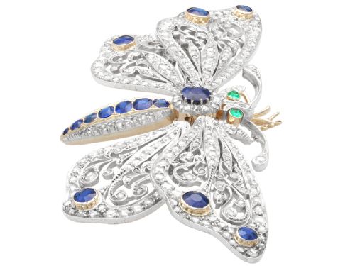 fig 4. An antique butterfly brooch constructed from gold and silver, featuring openwork wings set with diamonds, sapphire details, and green emerald eyes.