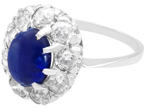 fig 5. An antique 14ct white gold ring featuring an oval cabochon blue sapphire surrounded by a halo of round diamonds.