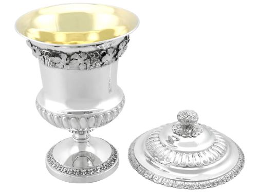fig 7. A Victorian sterling silver presentation cup and cover decorated with a grape leaf band, resting on a round ebonised wood plinth.