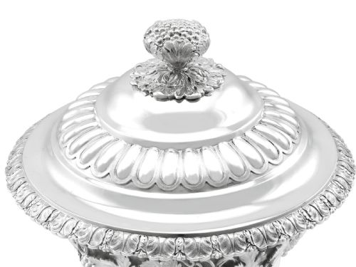 fig 8. A Victorian sterling silver presentation cup and cover decorated with a grape leaf band, resting on a round ebonised wood plinth.