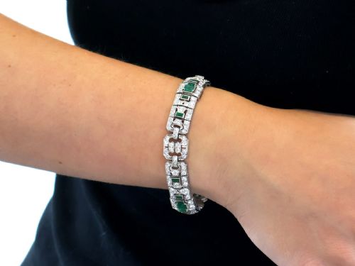 fig 4. An Art Deco platinum strap bracelet featuring geometric links set with diamonds and green accent emeralds.