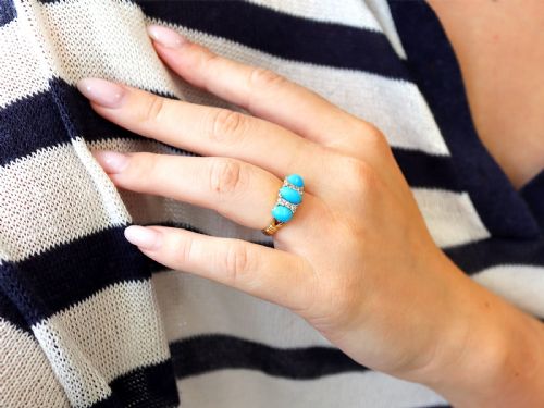 fig 2. A late Victorian 15ct yellow gold ring featuring three oval turquoise cabochons separated by small diamond accents.