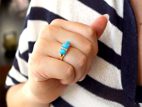 fig 3. A late Victorian 15ct yellow gold ring featuring three oval turquoise cabochons separated by small diamond accents.
