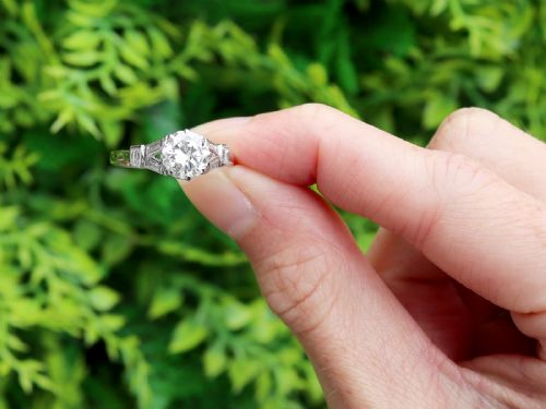 fig 1. An Art Deco platinum ring featuring a central round solitaire diamond flanked by geometric baguette-cut diamond shoulders.