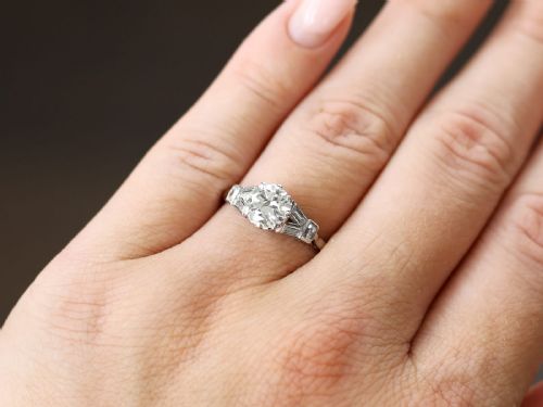 fig 2. An Art Deco platinum ring featuring a central round solitaire diamond flanked by geometric baguette-cut diamond shoulders.