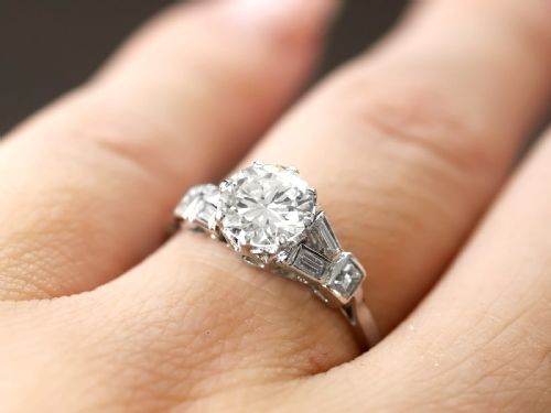 fig 3. An Art Deco platinum ring featuring a central round solitaire diamond flanked by geometric baguette-cut diamond shoulders.