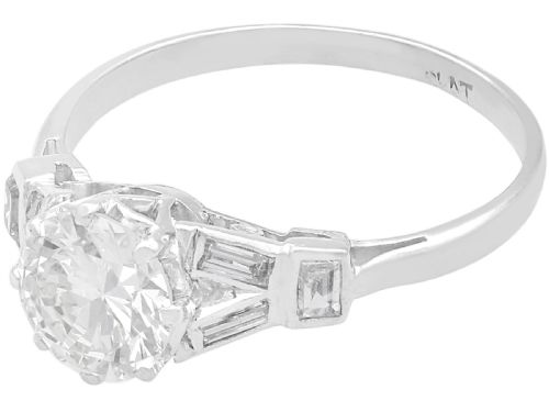 fig 4. An Art Deco platinum ring featuring a central round solitaire diamond flanked by geometric baguette-cut diamond shoulders.