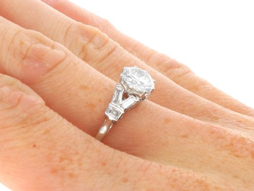 fig 9. An Art Deco platinum ring featuring a central round solitaire diamond flanked by geometric baguette-cut diamond shoulders.