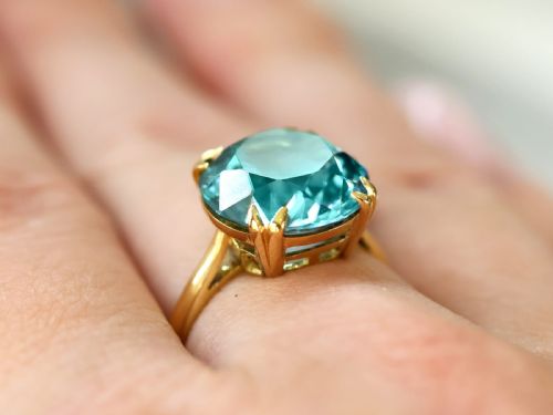 fig 3. An Edwardian 18ct yellow gold solitaire ring mounted with a round brilliant cut vibrant blue zircon in a claw setting.