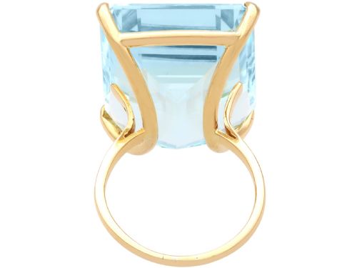 fig 4. A substantial rectangular emerald-cut light blue aquamarine gemstone secured in a four-claw 18ct yellow gold ring mounting.