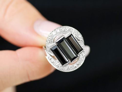 fig 3. An Art Deco style platinum dress ring displaying three vertical rectangular black onyx plaques enclosed within a circular diamond-set halo frame.
