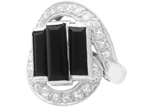 fig 4. An Art Deco style platinum dress ring displaying three vertical rectangular black onyx plaques enclosed within a circular diamond-set halo frame.