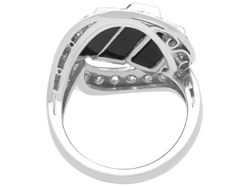 fig 5. An Art Deco style platinum dress ring displaying three vertical rectangular black onyx plaques enclosed within a circular diamond-set halo frame.