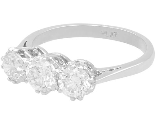 fig 3. A platinum trilogy ring featuring three round brilliant diamonds set in individual claw mounts along a slender polished band stamped PLAT.