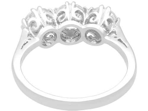 fig 4. A platinum trilogy ring featuring three round brilliant diamonds set in individual claw mounts along a slender polished band stamped PLAT.