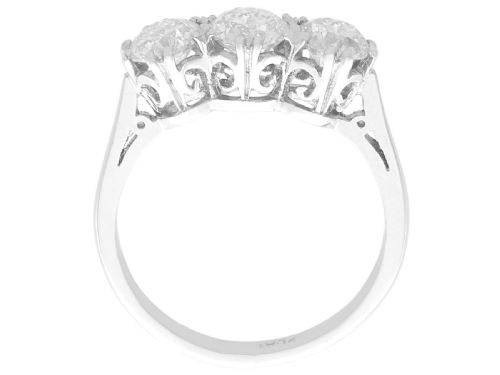 fig 5. A platinum trilogy ring featuring three round brilliant diamonds set in individual claw mounts along a slender polished band stamped PLAT.