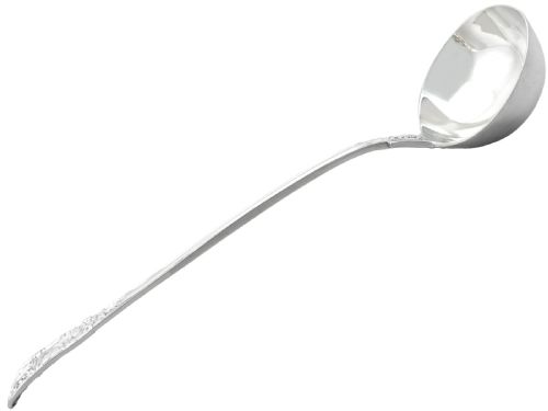 fig 1. An antique Victorian sterling silver soup ladle in Queens pattern featuring a deep round bowl and an intricately carved handle.