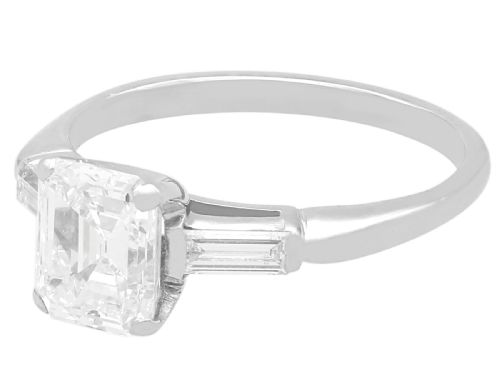 fig 4. A platinum solitaire ring featuring a central square step-cut diamond flanked by two baguette diamonds on a plain band.