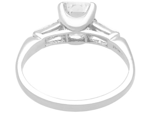 fig 5. A platinum solitaire ring featuring a central square step-cut diamond flanked by two baguette diamonds on a plain band.