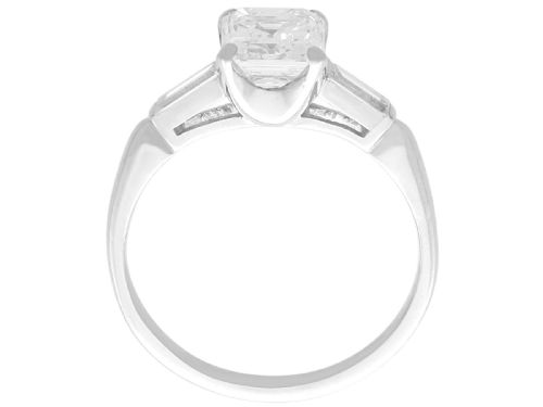 fig 6. A platinum solitaire ring featuring a central square step-cut diamond flanked by two baguette diamonds on a plain band.
