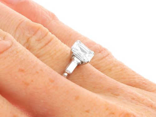fig 8. A platinum solitaire ring featuring a central square step-cut diamond flanked by two baguette diamonds on a plain band.