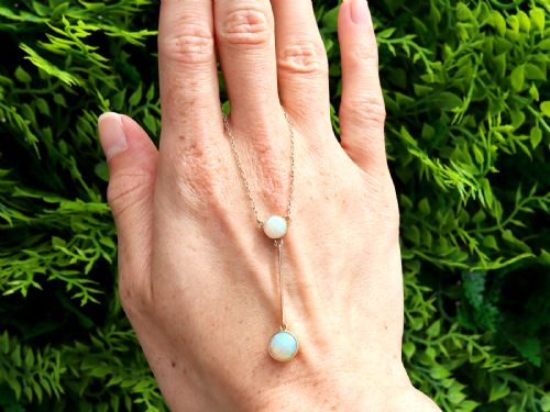 fig 1. Late Victorian 15ct yellow gold lavaliere necklace featuring two bezel-set round opal cabochons linked by a straight gold bar.