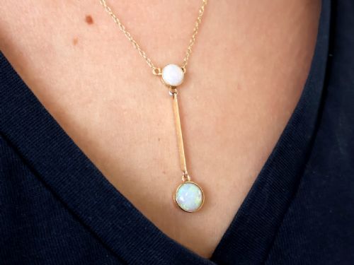 fig 2. Late Victorian 15ct yellow gold lavaliere necklace featuring two bezel-set round opal cabochons linked by a straight gold bar.