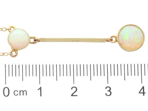 fig 6. Late Victorian 15ct yellow gold lavaliere necklace featuring two bezel-set round opal cabochons linked by a straight gold bar.