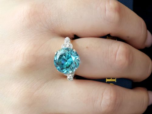 fig 2. An Art Deco 9ct yellow gold ring featuring a large round-cut blue zircon flanked by diamond-set shoulders.