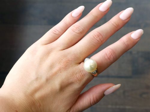 fig 2. A vintage 18ct yellow gold ring featuring a central round cream cultured pearl flanked by two triangular diamonds.